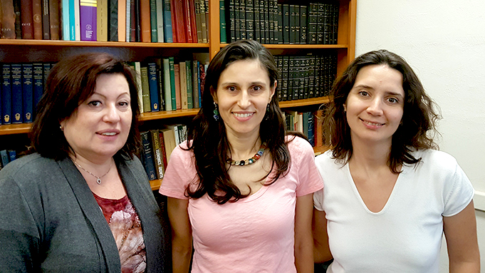 Photo of Ariane, Valentina Hartarska, and Anastasia in front of bookshelf.