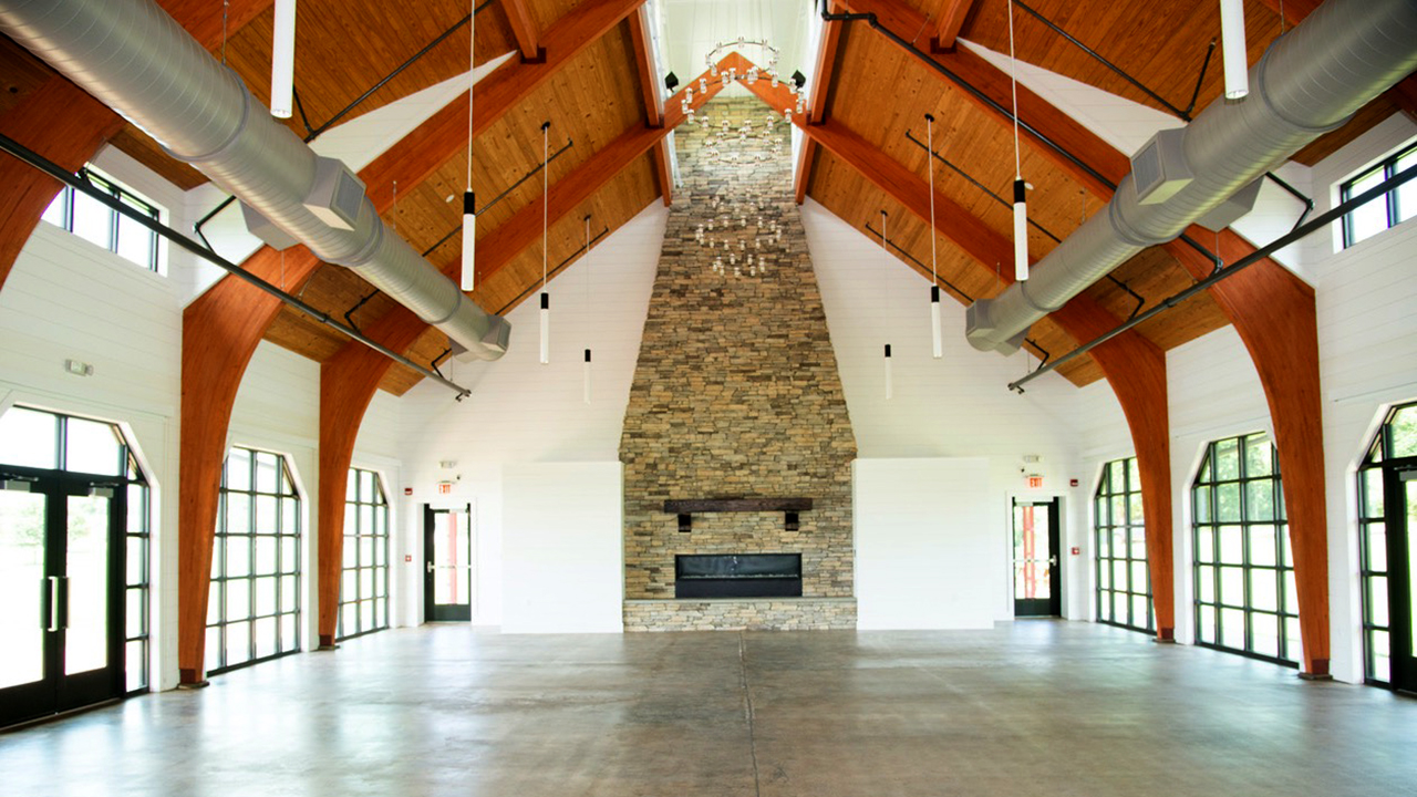 The renovated Ag Heritage Park Pavilion features a large stone fireplace, glass doors and exposed wood ceilings.