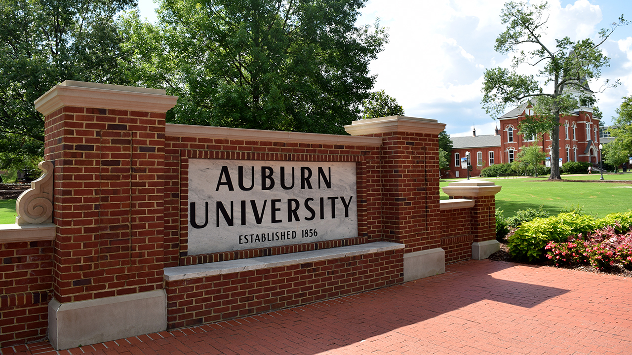 Auburn University, established 1856, main sign on campus that tourists & students take graduation pictures in front of. Sunny summer day.