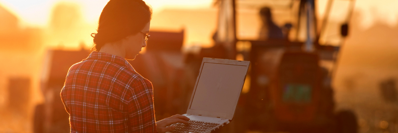 College-girl-in-plaid-with-laptop-farm-tractor-Ag-Communications-major-sm College-girl-in-plaid-with-laptop-farm-tractor-Ag-Communications-major-sm