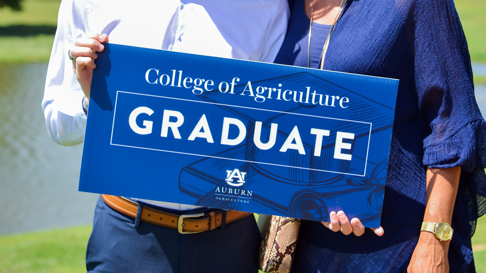 Auburn-University-College-of-Ag-Graduates-Congrats-Students-at-lake-front-leather-belt-snake-skin-purse-gold-jewelry-Alabama-hot-sun-water-2022
