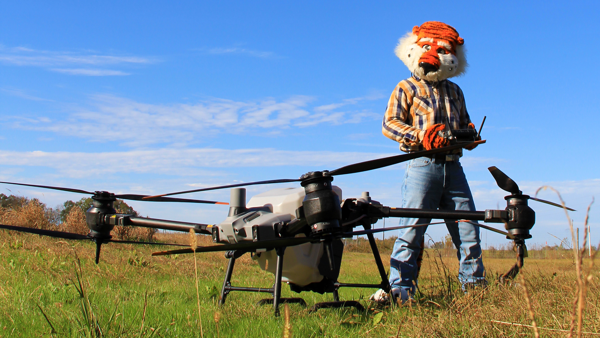 Aubie-wearing-plaid-shirt-remotely-pilots-UAV-aircraft-UAS-on-farm-land-in-Alabama-student-college-Path-to-the-Plains-with-Southern-Union