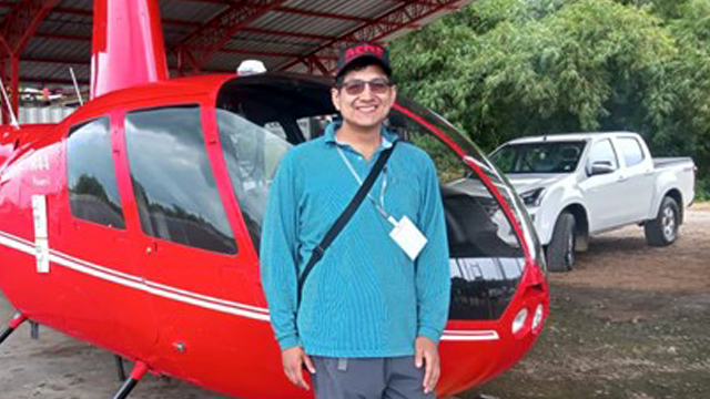 Rommel-Munoz-Alvarado-visiting-scholar in front of a helicopter