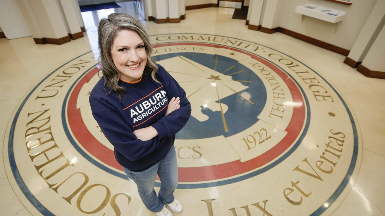 Madisen Cope poses in front of the Southern Union State Community College seal.