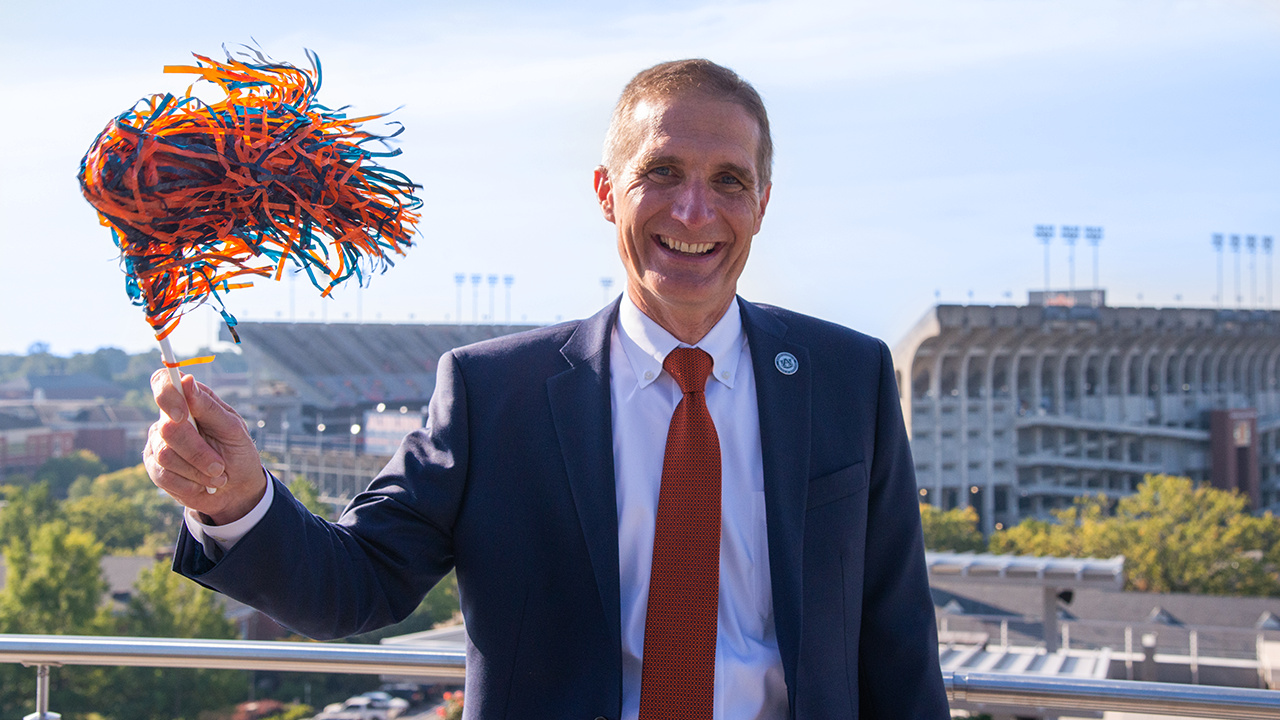 Dean Paul Patterson waves an Auburn colored shaker in front of Jordan-Hare stadium